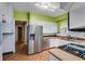 Well-lit kitchen with stainless steel appliances, ample cabinetry, light countertops, and view to breakfast room at 407 E College E St, Bowdon, GA 30108