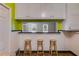 The pass through bar in this kitchen features a breakfast bar with seating, view to the living room and white cabinetry at 407 E College E St, Bowdon, GA 30108