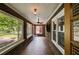Inviting sunroom featuring brick walls, tile floors, large windows, and a ceiling fan at 407 E College E St, Bowdon, GA 30108