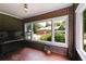 Bright sunroom featuring brick walls, a mosaic-tiled floor, a piano, and multiple windows at 407 E College E St, Bowdon, GA 30108