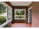 Charming sunroom with red brick walls and tiled flooring, perfect for enjoying natural light and outdoor views at 407 E College E St, Bowdon, GA 30108