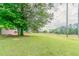 Lush backyard with mature trees and green grass, offering a private retreat for outdoor activities at 725 Signature Trce, Palmetto, GA 30268