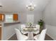 Inviting dining room featuring a glass-top table, white chairs, and a elegant chandelier at 725 Signature Trce, Palmetto, GA 30268
