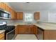 Well-lit kitchen featuring stainless steel appliances, wooden cabinets, and neutral countertops at 725 Signature Trce, Palmetto, GA 30268
