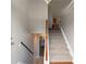 Carpeted staircase with wooden handrail leading to upper level of the home, with neutral paint throughout at 725 Signature Trce, Palmetto, GA 30268