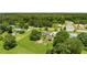 An aerial view of a green home featuring an expansive yard, mature trees, and a long, paved driveway for multiple vehicles at 107 Bowen Rd, Stockbridge, GA 30281