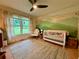 Bright Bedroom with mountain wall art, wooden floors, sunny windows, and a comfortable armchair at 107 Bowen Rd, Stockbridge, GA 30281