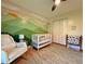 Charming Bedroom with a white crib, mountain mural, cozy armchair, and lots of natural light at 107 Bowen Rd, Stockbridge, GA 30281