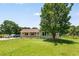 Inviting one-story home featuring a covered porch, a large tree in the front yard, and ample parking space at 107 Bowen Rd, Stockbridge, GA 30281