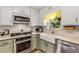 Charming kitchen featuring stainless steel appliances, decorative backsplash, and a farmhouse sink at 107 Bowen Rd, Stockbridge, GA 30281