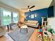 A cozy living room featuring a modern ceiling fan, a blue accent wall, and ample natural light at 107 Bowen Rd, Stockbridge, GA 30281