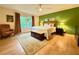 Bright main bedroom with an accent wall, neutral furniture, and hardwood-style flooring at 107 Bowen Rd, Stockbridge, GA 30281