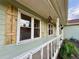 Close-up of the covered porch with rustic shutters and space for flowers and birdhouses at 107 Bowen Rd, Stockbridge, GA 30281