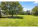 Expansive yard with lush green grass, mature trees, and a shed in the background at 107 Bowen Rd, Stockbridge, GA 30281