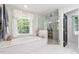 Bright bathroom features a soaking tub, glass-enclosed shower, and marble tile flooring at 1135 Timberland Se Dr, Marietta, GA 30067