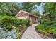 A detached red brick garage is accompanied by beautiful landscaping and walkway at 1135 Timberland Se Dr, Marietta, GA 30067