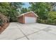 View of a brick detached garage with a large driveway at 1135 Timberland Se Dr, Marietta, GA 30067