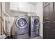 Modern laundry room with stainless steel washer and dryer, white cabinets, and tiled floor at 1135 Timberland Se Dr, Marietta, GA 30067