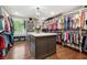 Spacious walk-in closet with custom shelving, storage island, and a variety of clothing and accessories on display at 1135 Timberland Se Dr, Marietta, GA 30067