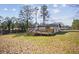 Backyard view featuring a spacious deck, chimney, and mature trees at 3698 Sharon Dr, Powder Springs, GA 30127