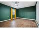 Bedroom features laminate floors, a ceiling fan, and abundant natural light from a window with yellow curtains at 3698 Sharon Dr, Powder Springs, GA 30127