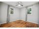 Bright bedroom with hardwood floors, ceiling fan, and two windows providing natural light at 3698 Sharon Dr, Powder Springs, GA 30127