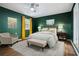 Staged bedroom featuring green walls, neutral furniture and decor, and hardwood flooring at 3698 Sharon Dr, Powder Springs, GA 30127