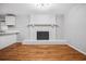 Living area with refinished hardwood floors and a painted brick fireplace at 3698 Sharon Dr, Powder Springs, GA 30127