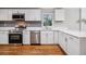 Bright kitchen with white cabinets, stainless steel appliances, and quartz countertops at 3698 Sharon Dr, Powder Springs, GA 30127