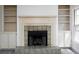 Cozy fireplace with stone surround flanked by built-in shelving units and windows for natural light at 742 Olde Towne Ln, Marietta, GA 30068