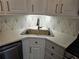 Stylish kitchen sink with neutral countertops, geometric backsplash, and stainless steel appliances at 742 Olde Towne Ln, Marietta, GA 30068