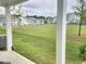View of a large backyard and neighborhood green space from the covered patio at 1177 Chastain Dr, Sugar Hill, GA 30518