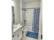 Bathroom features tub with shower, blue and white shower curtain, vanity, and toilet at 1177 Chastain Dr, Sugar Hill, GA 30518