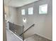 Hallway with carpet and a railing, offering a view of natural light from the accent windows at 1177 Chastain Dr, Sugar Hill, GA 30518
