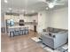 Spacious kitchen and living room layout, with an island, stainless appliances, and an adjacent sitting area with a gray sofa at 1177 Chastain Dr, Sugar Hill, GA 30518
