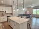 Open floor plan showcases a kitchen island with seating that flows into a comfortable living area with natural light at 1177 Chastain Dr, Sugar Hill, GA 30518