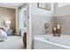 Neutral bathroom featuring a large soaking tub and tiled wall detail at 2078 Brookhill Way, Snellville, GA 30078
