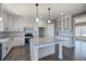 Modern kitchen features white cabinets, granite countertops, stainless steel appliances, and a functional island with pendant lighting at 30 Grand Georgian Ne Ct, Cartersville, GA 30121