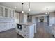 Open kitchen featuring white cabinets, granite countertops, stainless steel appliances, and a functional island with pendant lighting at 30 Grand Georgian Ne Ct, Cartersville, GA 30121