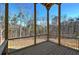 Covered wooden porch featuring black railings and rustic pillars, providing a peaceful outdoor view of nature at 30 Grand Georgian Ne Ct, Cartersville, GA 30121