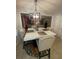 This kitchen boasts a square kitchen table, four chairs, and a unique light fixture above, with a view to the living room at 4237 Webb Meadows Dr, Loganville, GA 30052