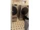 This laundry room includes front loading washer and dryer and black and white flooring at 4237 Webb Meadows Dr, Loganville, GA 30052