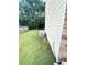 Side yard of the house with stone details and green grass at 4237 Webb Meadows Dr, Loganville, GA 30052