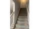 Carpeted staircase with white handrails leading to the upper level of the home at 4237 Webb Meadows Dr, Loganville, GA 30052