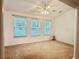 Bright bedroom with three windows, ceiling fan, neutral carpet, and white walls at 6214 Treeridge Nw Dr, Acworth, GA 30101
