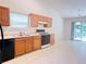 Kitchen featuring white tile floors and wood cabinets with black appliances at 6214 Treeridge Nw Dr, Acworth, GA 30101