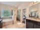 Luxury bathroom with separate soaking tub, glass shower, and granite countertop with double sinks at 2433 Santa Rosa St, Alpharetta, GA 30009