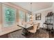 Bright dining room with a dark table, patterned chairs, and window views at 2433 Santa Rosa St, Alpharetta, GA 30009
