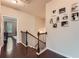 View of the staircase with dark wood floors and black and white pictures on the wall at 2433 Santa Rosa St, Alpharetta, GA 30009