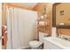 Bathroom with white fixtures, orange walls, and chrome shelving for storage at 3709 Mcguire Nw St, Kennesaw, GA 30144